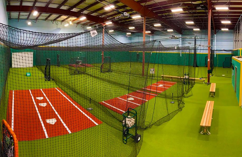 A wide angle look at the facility's 3 main batting cages with turf field in the background.